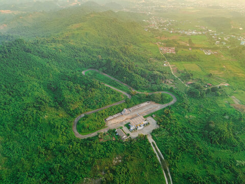 Aerial view of Kalan Circuit surrounded by lush green hills and dense tropical forest in Samarinda, East Kalimantan, Indonesia.