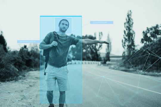 Man standing on road while using facial recognition technology for surveillance