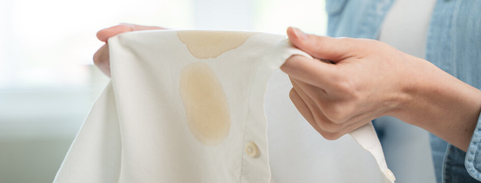 Housewife, asian young woman hand in holding shirt, showing making stain, spot dirty or smudge on clothes, dirt stains for cleaning before washing, making household working at home. Laundry and maid.