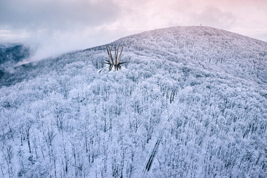 January 3, 2026, Kosmaj Mountain, Serbia: Star-shaped Kosmaj partisan memorial rising from a frost-white hillside forest at dawn