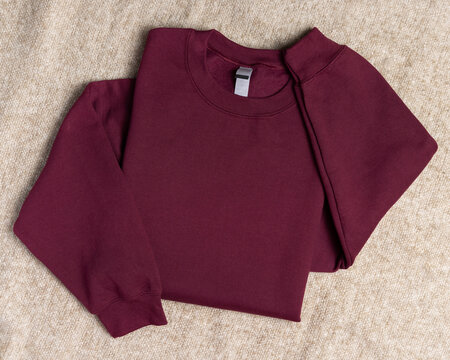 Blank dark red unisex sweatshirt mockup, folded apparel template, copy space on front and sleeves