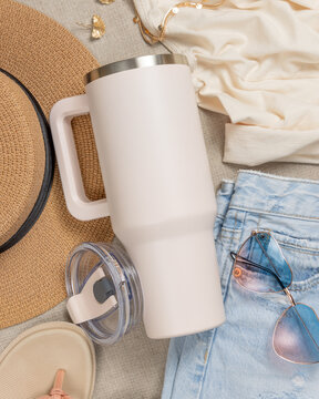 Blank ivory 40oz tumbler mockup, stainless steel travel thermos on denim and dark red sweatshirt