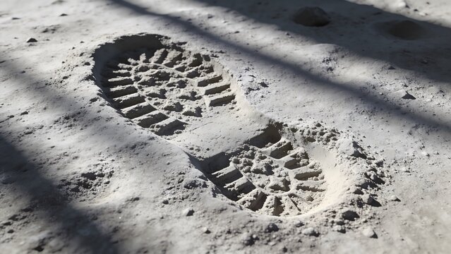 Human boot footprints on dusty ground representing walking journey and exploration concept
