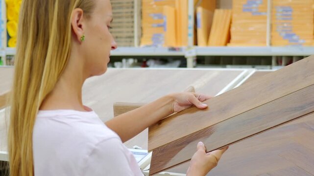 Woman Choosing Laminate Flooring Samples in Home Improvement Store