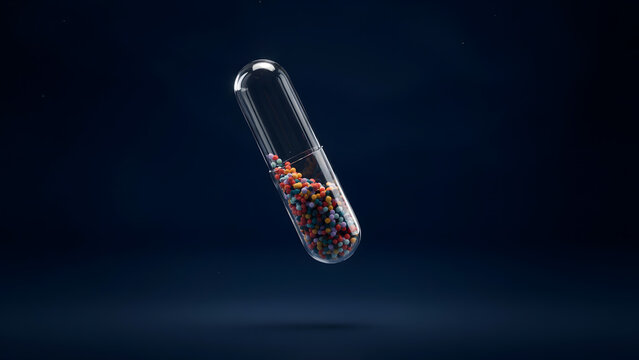 A transparent medical pill capsule filled with colorful small spheres