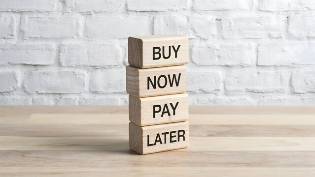A vertical stack of wooden blocks spelling out buy now pay later