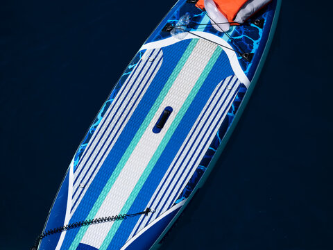 Paddle board tied to a boat at sea
