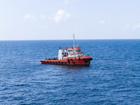 Aerial view of a tugboat navigating the blue ocean near Manggis Port in Manggis, Bali, Indonesia.