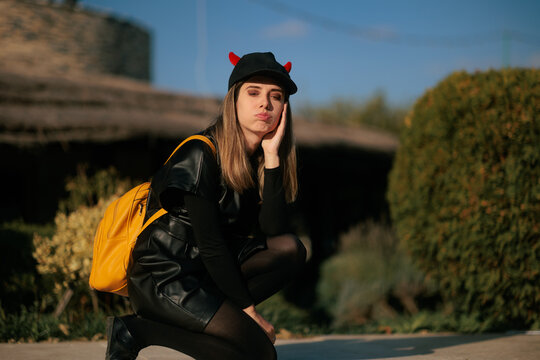 Bored Disappointed Woman Wearing Devil Horns Cap On Halloween.  Unhappy lonely female feels confused deciding her festive autumn holiday plans outdoor