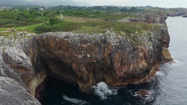 Aerial View of the Rugged Rocky Coastline and Atlantic Ocean Waves Behind Playa de Gulpiyuri in Asturias, Northern Spain