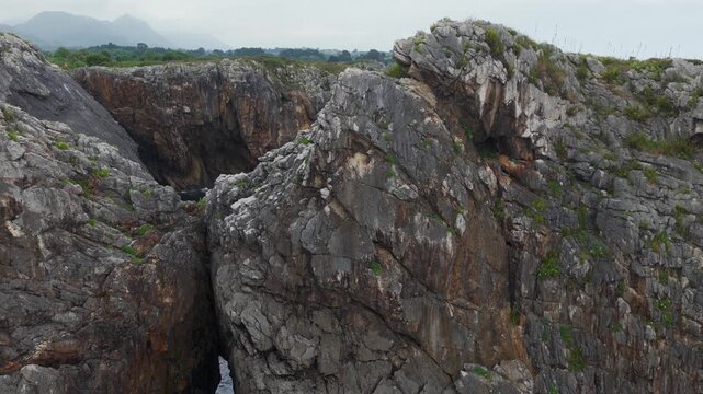 Aerial View of the Rugged Rocky Coastline and Atlantic Ocean Waves Behind Playa de Gulpiyuri in Asturias, Northern Spain