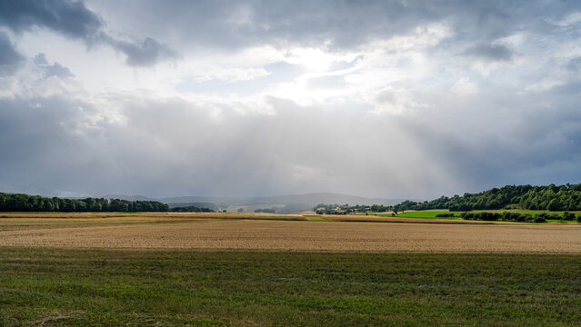 Sun Rays Through Rain Shower over Bavarian Rh&ouml;n Landscape in Summer