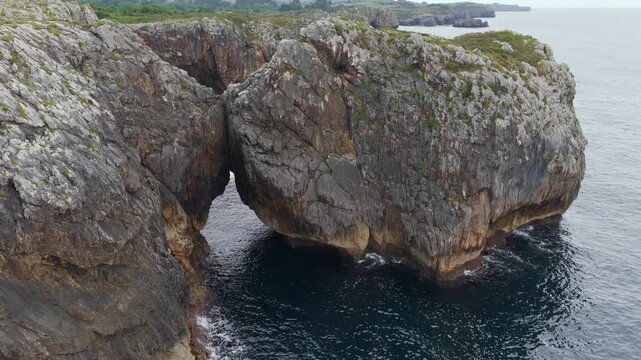 Aerial View of the Rugged Rocky Coastline and Atlantic Ocean Waves Behind Playa de Gulpiyuri in Asturias, Northern Spain