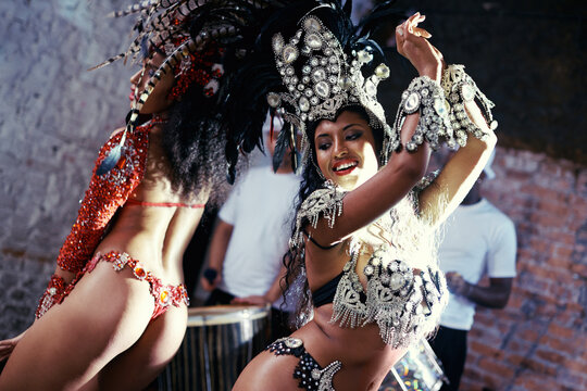 Party, carnival or women in costume dancing for celebration, music culture or samba in Brazil. Girl friends, smile or dancers with rhythm or fashion at festival, parade or fun show in Rio de Janeiro