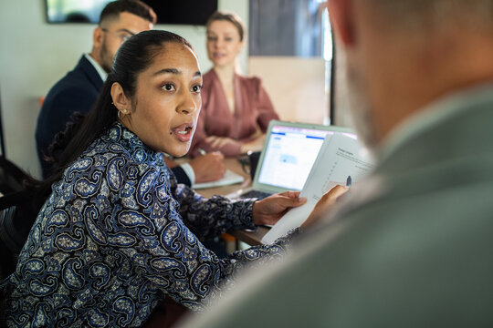 Confident businesswoman leading team discussion in office