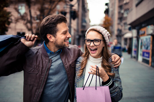 Happy couple shopping on city street in autumn