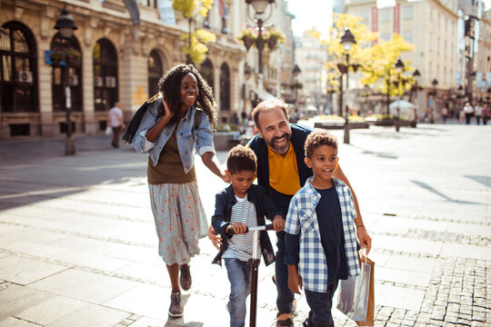 Parents and children walking on sunny city street
