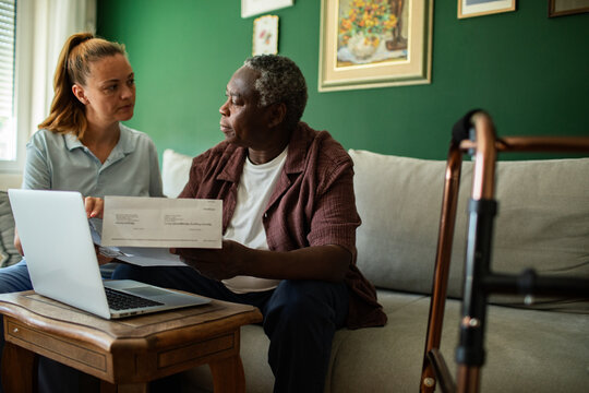 Caregiver helping senior with bills at home