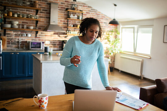 Woman on video call working from home kitchen