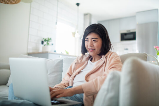 Smiling woman working on laptop at home