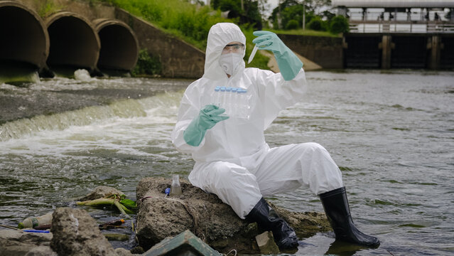 Ecologist Inspecting Water Sample Tube for Outdoor Pollution Check