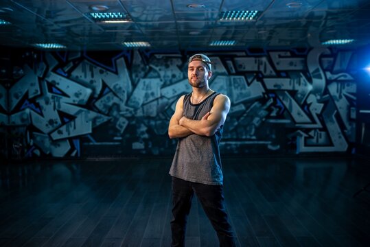 Bearded man standing with crossed arms inside dance studio