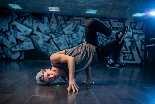 Breakdancer boy executing dynamic headstand balance with bent knees
