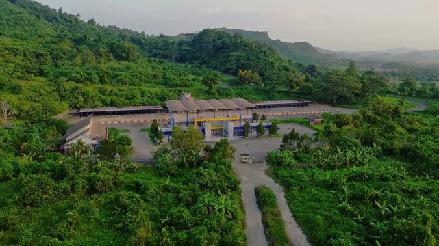 Aerial view of Sirkuit Kalan racetrack surrounded by lush tropical vegetation and hills in Samarinda, East Kalimantan, Indonesia.