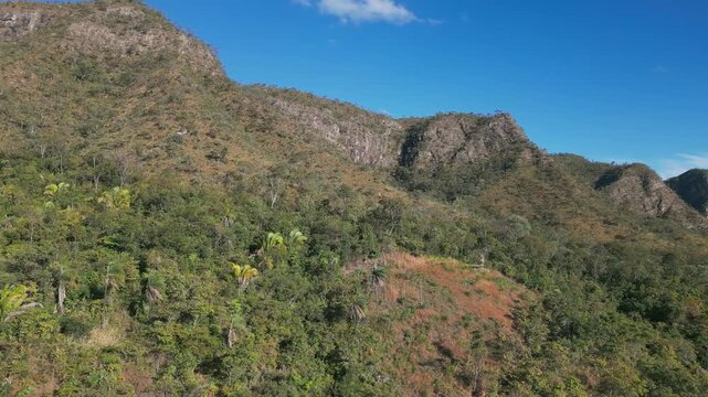 Quartzite escarpments rise above the Sao Miguel River at Vale da Lua, Chapada dos Veadeiros National Park, Alto Paraiso de Goias, Goias, Brazil, drone parallax.