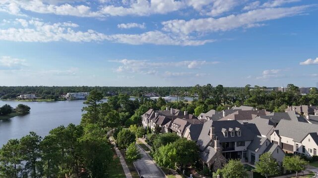 Aerial view of large mansion houses with swimming pool, in affluent neighborhood by Woodlands lake, Houston, Texas, expensive suburban homes surrounding by lush green trees, USA