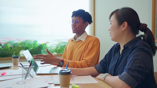 Diverse business colleagues discussing financial data and roadmap strategy on tablet computer in modern office	