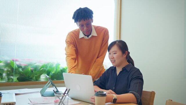 Diverse business colleagues discussing financial data and roadmap strategy on tablet computer in modern office	