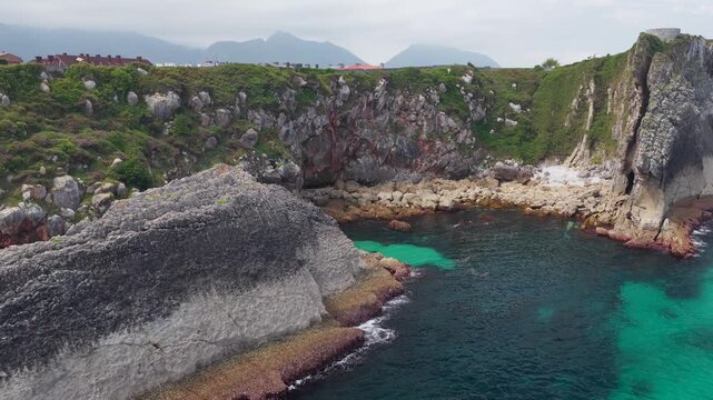 Aerial View of the Sea Cliffs and Green Grass Footpath Along Paseo de San Pedro Hiking Trail in Llanes, Asturias, Northern Spain