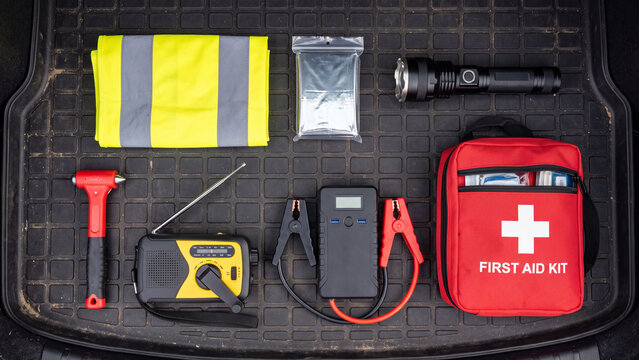 Essential car safety and emergency kit items including first aid, reflective vest, and jump starter.