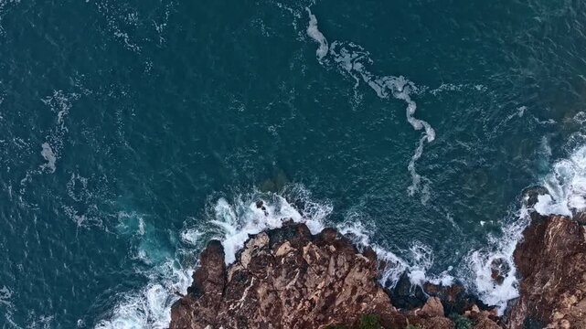 Fels in der Brandung. Raues Wasser nach einem Sturm. Drohne von oben mit langsamer Bewegung. T&uuml;rkises Wasser. Raue See mit braunen Felsen. Wellengang. D-Log-Originale vorhanden