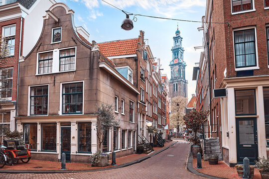 Amsterdam, Netherlands. Street view to the Mint Tower (Munttoren) on Muntplein square. Cosy street crossroads. Autumn evening sunny day with blue sky with clouds.