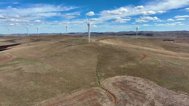 Aerial view of wind turbines on rolling hills in the rural landscape of Burra, South Australia, Australia.