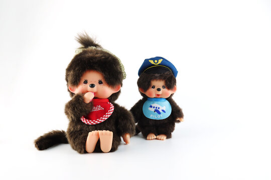 popular monkey classic doll toy , Monchichi or Monchhichi , Japanese cute pilot costume monkey fur doll display on white table with white wall background in souvenir tourist shop in Japan art toy