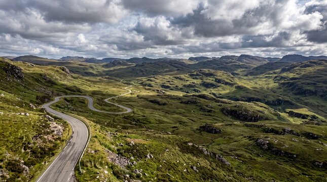 Winding road through the dramatic, rugged landscape of the highlands under a cloudy sky