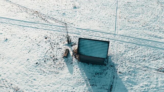 Aerial view of the Wooden Chapel in Marianska Hora surrounded by a snow-covered landscape with distant fog and a ski lift in Albrechtice v Jizerskych horach, Liberecky kraj, Czechia.
