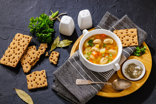 Old fashioned poultry meatball soup in clear broth