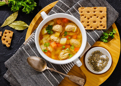 Old fashioned poultry meatball soup in clear broth