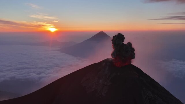 Aerial view of Volcan de Fuego rising above a sea of clouds during a vibrant sunset in Yepocapa, Chimaltenango Department, Guatemala.