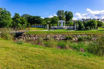 Obraz premium White pavilion and wooden bridge in public seaside park landscape