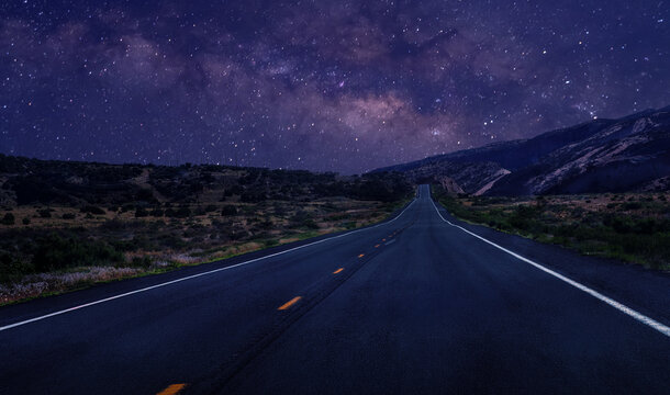 country road under night sky with Milky Way, starry sky over the mountains