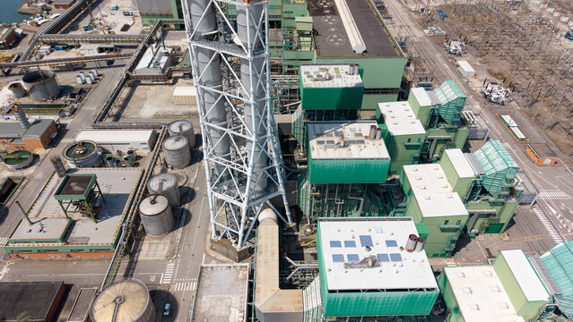 Aerial view of the Stazione Elettrica TERNA - TAVAZZANO EST power plant featuring tall chimneys, storage tanks, and industrial buildings in Montanaso Lombardo, Lombardia, Italy.