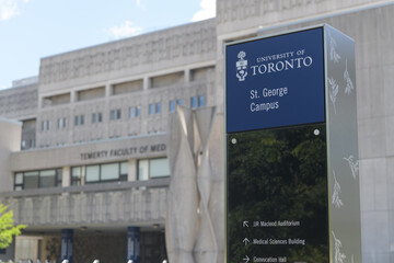 Fototapeta premium wayfinding marker on the St George Campus of the University of Toronto with a defocused view of Temerty Faculty of Medicine (Medical Sciences Building, MSB) 1 King’s College Circle