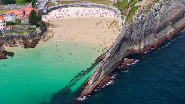 Aerial View of the Golden Sand Beach, Turquoise Ocean Water, and Sea Cliffs at Playa del Sabl&oacute;n Below Paseo de San Pedro in Llanes, Asturias, Northern Spain