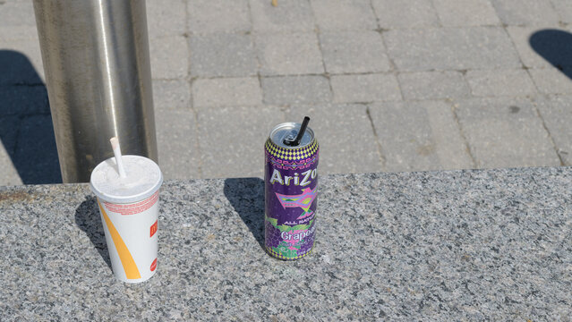 discarded beverage cup from McDonald's Canada and aluminum can of AriZona Grapeade, Toronto
