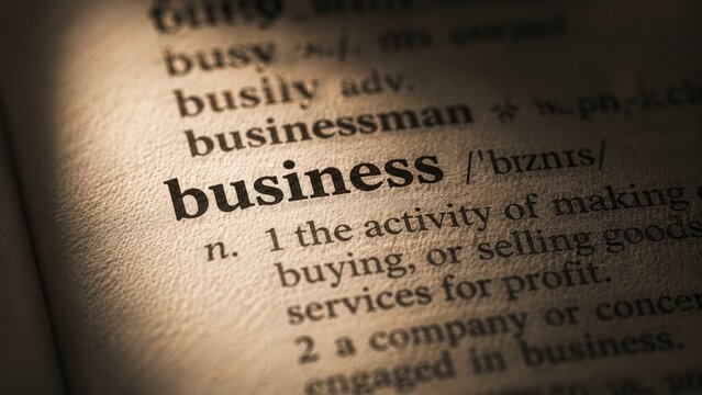 The word business definition printed inside a vintage dictionary text page with close up macro focus.